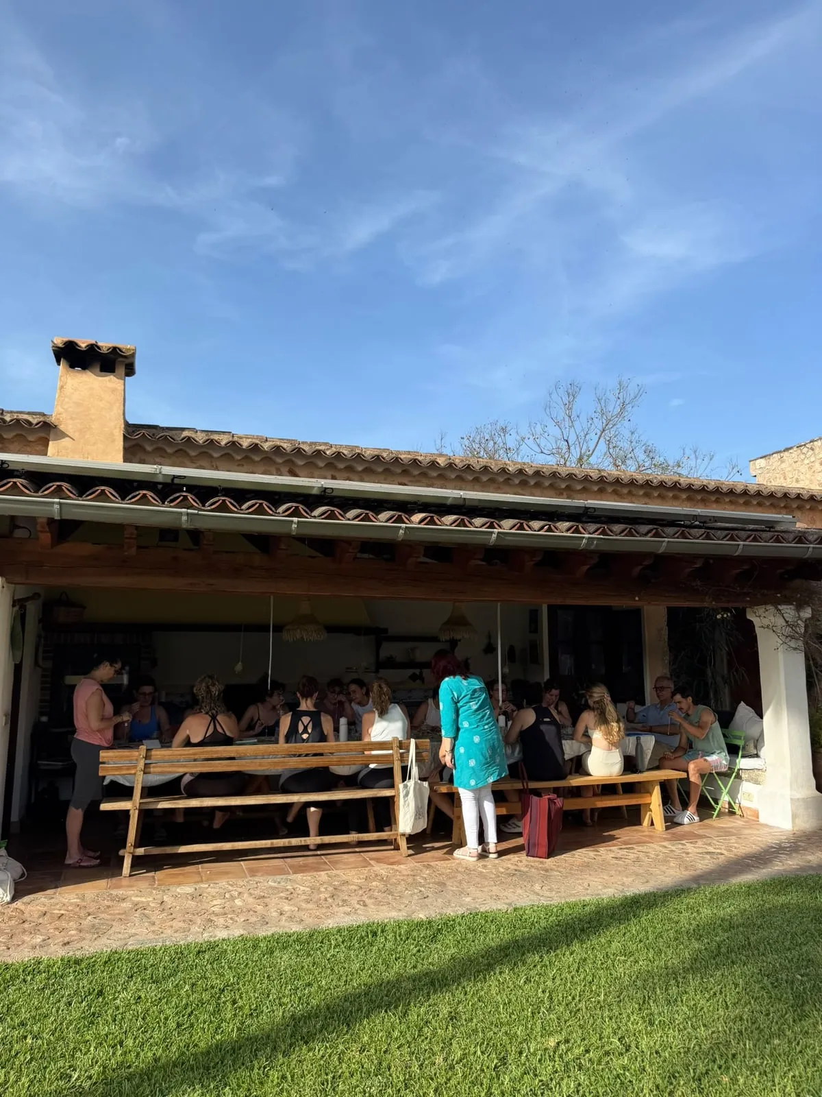 Una mesa larga bajo el porche de una casa en Sóller, con el grupo de un taller sentado alrededor
